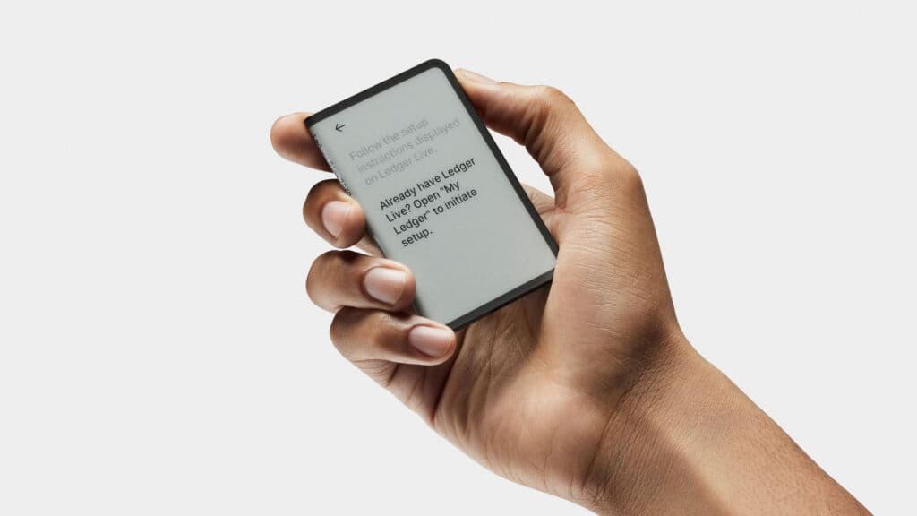 Ledger hardware wallet held in a hand
